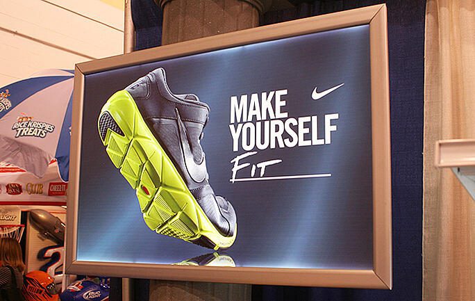 Nike store display featuring shoe and “Make Yourself Fit” slogan.